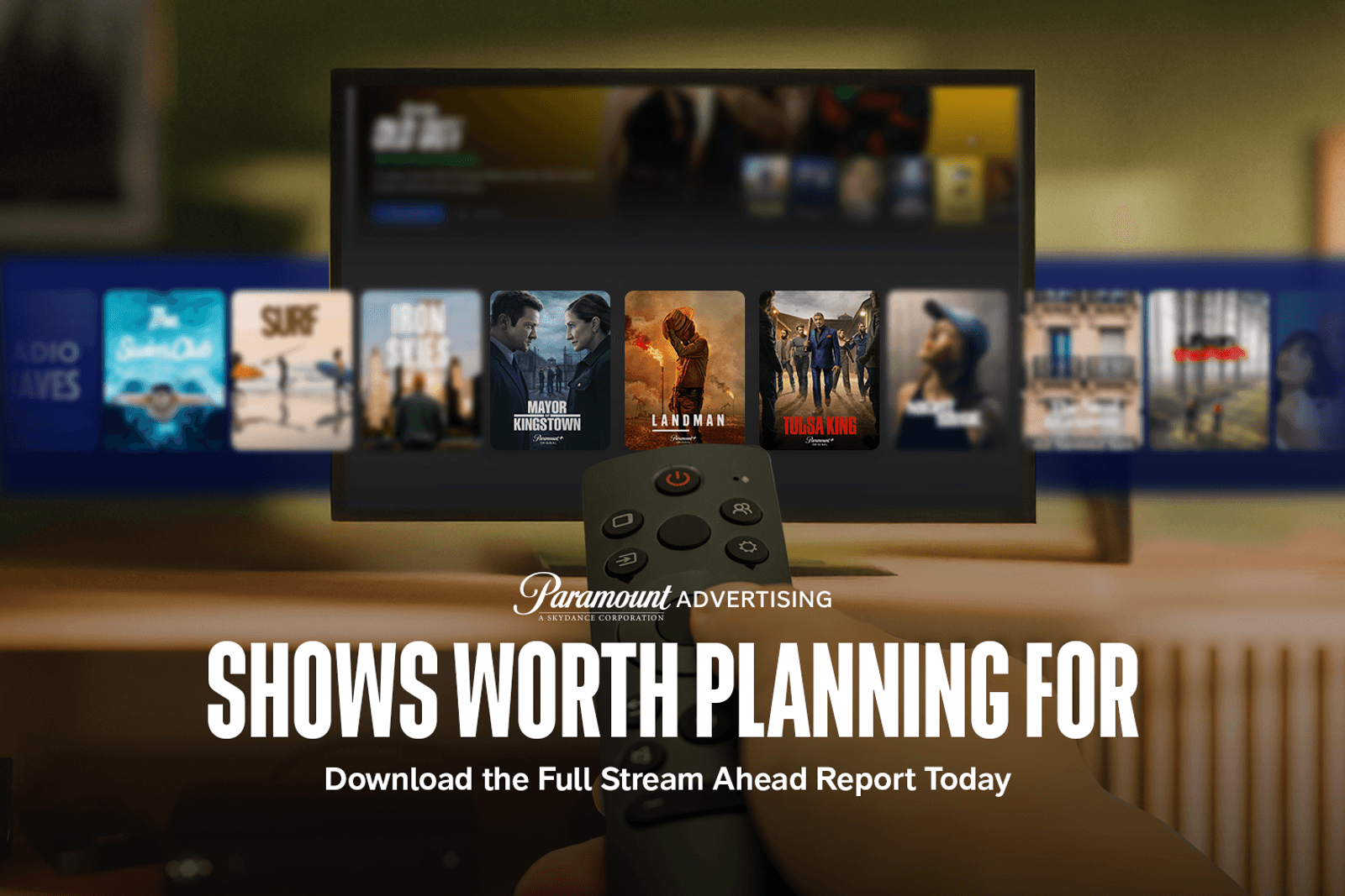 Person holding remote control aimed at television featuring a streaming platform on screen.